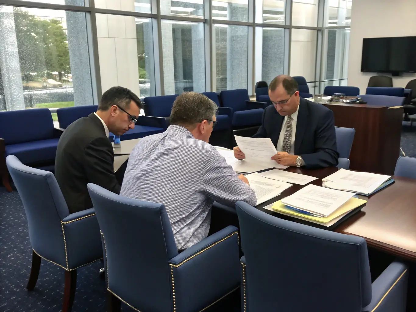 A professional security consultant in a suit reviewing compliance documents with a government contractor in a modern, well-lit office environment, conveying trust and expertise.